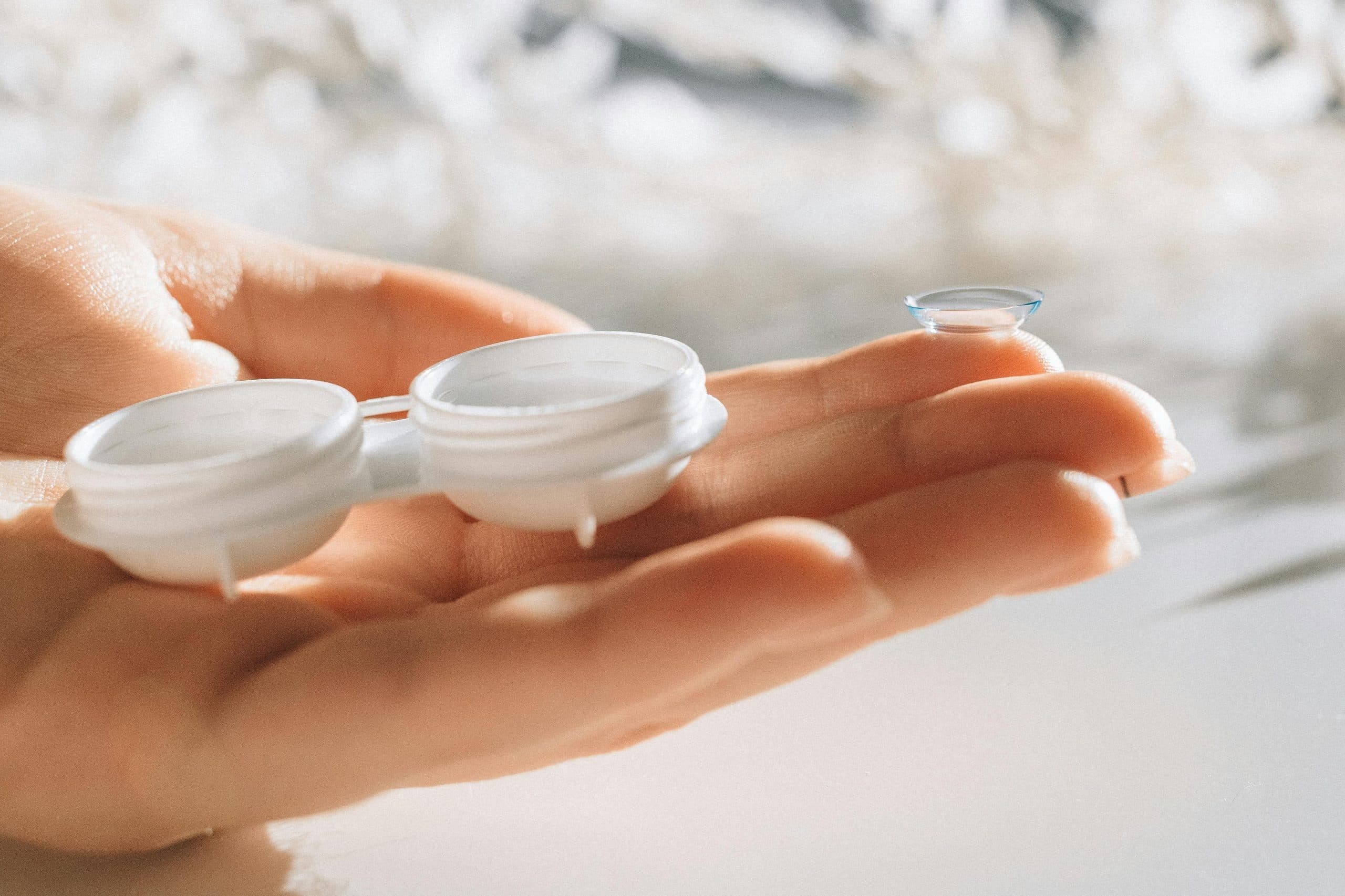 Contact lens and case held in an open hand